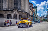 Fototapeta Uliczki - HDR - Gelber amerikanischer Oldtimer fährt auf der Hauptstrasse durch Havanna Kuba - HDR - Serie Kuba Reportage