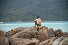 Old Man Sitting On The Rock At The Sea
