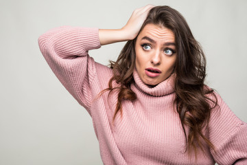 Wall Mural - scowling young woman scratching her head isolated on white