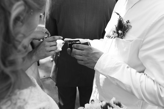 the priest puts on the rings to the bride and groom