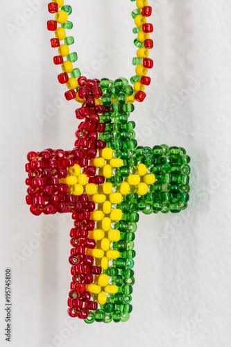 Fotografie, Obraz Close up of a Christian Cross made out of Rasta colored beeds