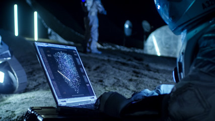 Wall Mural - astronaut on the alien planet works with ai analysis on a laptop. in the background her crew member 