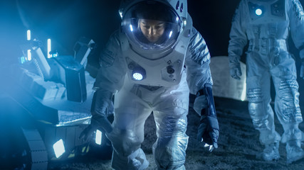 Wall Mural - two astronauts on an alien planet discover something interesting on the ground. space travel and sol