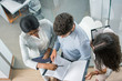 © Bojan - Top view of business people working together at meeting, discussing document in the office.