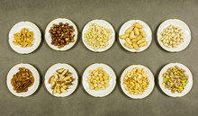 Different Types Of Shelled And Unshelled Nuts Are Presented On Plates. View From Above.