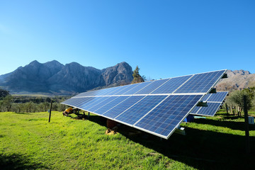 solar panels with photovoltaic modules for renewable energy with blue sky and mountains in the back 