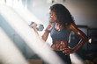 © Joshua Resnick - fit african american woman lifting iron in home gym