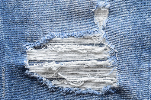 Jeans in wash blue with rip. Denim background, texture. Ripped ...