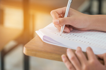Wall Mural - education test concept : blur of hand student holding pen for testing exams writing answer sheet or 