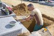 Man in grave using hammer and chisel