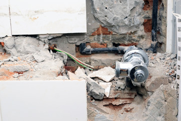 Plumber drilling on the toilet wall for repairing pipeline and renovation restroom.