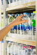 woman's hand  pick product from  convenience store refrigerator shelves