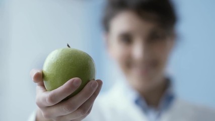 Wall Mural - Professional nutritionist holding a fresh apple