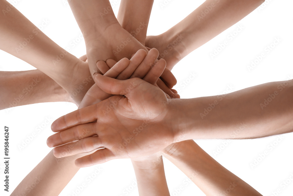 Young people putting hands together as symbol of unity, on white background