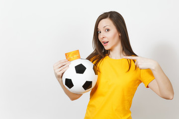 Wall Mural - Beautiful European young cheerful woman, football fan or player in yellow uniform holding credit card soccer ball isolated on white background. Sport, play football game, excitement lifestyle concept.