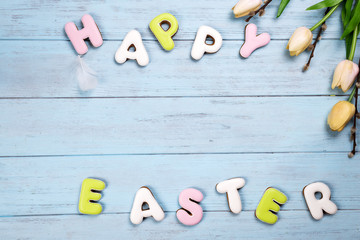 Sticker - Lettering from cookies Happy Easter on wooden blue background.