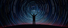 Man Silhouette On A Night Sky Background With Bright Stars Trails. Man Watching The Stars. Science, Education And Religion Team Concept Background. Elements Of This Image Furnished By NASA. 