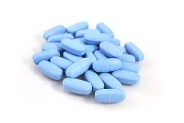 Big oval blue tablets closeup on white background