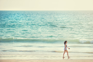 Wall Mural - Woman walk on an empty wild beach