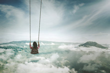 Young Woman Playing With Swing Above Mountain