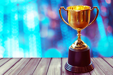 Wall Mural - chamption trophy on wood table with abstract bokeh light background, win concept.