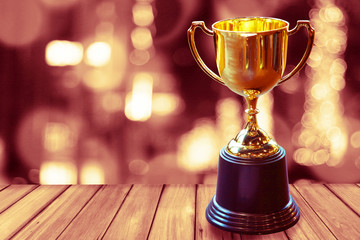 Wall Mural - chamption trophy on wood table warm theme for win concept.