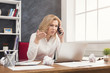 © Prostock-studio - Serious business woman at work talking on phone