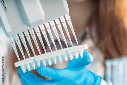 Cuadros en Lienzo Microbiological laboratory scientist woman with multi channel pipette going DNA