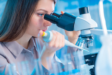 Young chemist in the laboratory. Scientist Using Microscope In Lab