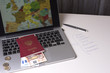 © Александр Овсянников - Russian passport with euro banknotes on the opened laptop with the map of Europe on a white sheet with the inscriptions of European countries. Planning your trip on vacation.