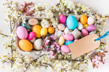 Easter holiday background.Easter chocolate candy eggs and spring flowers, minimalism, modern decoration, copy space.