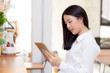 © N_studio - Beautiful asian young businesswoman holding tablet, woman looking mobile phone and working internet online coffee shop, career freelance business concept.