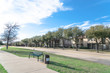 © trongnguyen - Exterior view of typical apartment near public park in Irving, Texas, USA. Bench and trash bin, concrete trail for walking, jogging, biking.