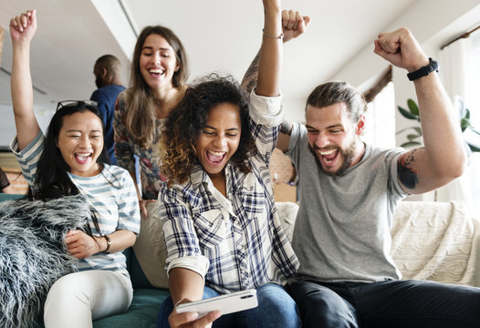 Group of diverse friends playing game on mobile phone