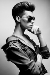 Handsome young man model with fashion haircut and sunglassesposi