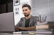 © Yakobchuk Olena - Business concept. Portrait of young tranquil businessman focused on laptop screen while sitting inside