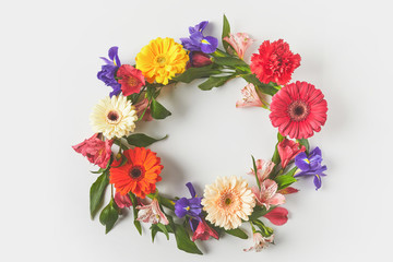 Sticker - top view of floral wreath made of beautiful colorful flowers and green leaves on grey