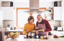 Senior Couple Preparing Food In The Kitchen.