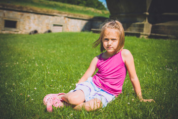 6 years girl sitting in the grass outdoors