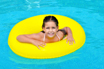 Real adorable girl relaxing in swimming pool