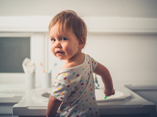 Wall Mural - Little boy standing by wash basin