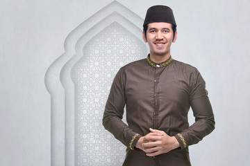 Poster - Smiling asian muslim man with cap and traditional dress