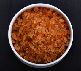 Wall Mural - Gravel sugar in bowl on black background