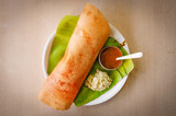 Fototapeta Sypialnia - Traditional Southern Indian rice Dosa on banana leaf.