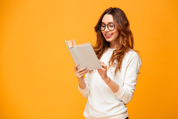 Poster - Smiling brunette woman in sweater and eyeglasses reading book