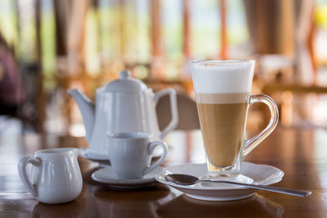 Wall Mural - Hot latte coffee in long cup on wooden table