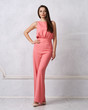 © Dmitry Tsvetkov - Charming female model with long brunette hair wearing fashionable sleeveless pink jumpsuit and heeled shoes posing against white wall on background. Gorgeous woman dressed in trendy apparel.