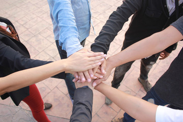 Sticker - Meeting teamwork concept,Friendship,Group people with stack of hands showing unity on concrete floor background