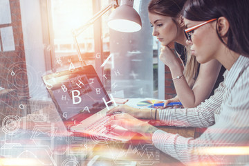 Wall Mural - two women working on new website design choosing pictures using the laptop surfing the internet