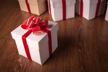 Wall Mural - One white festive gift box with a red bow against a background of white boxes